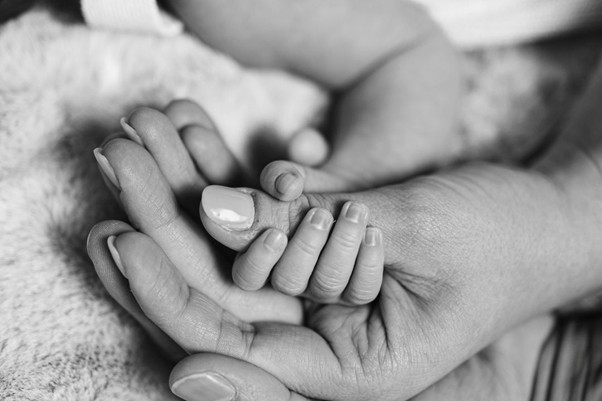 Baby hand holding thumb